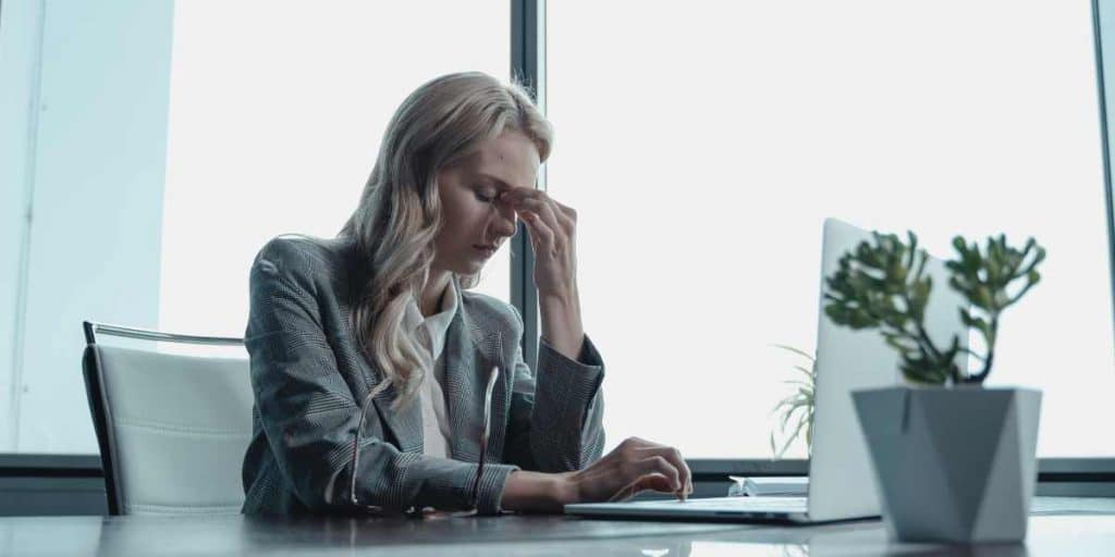 A Woman Working in an Office Experiences a Stress Induced Headache