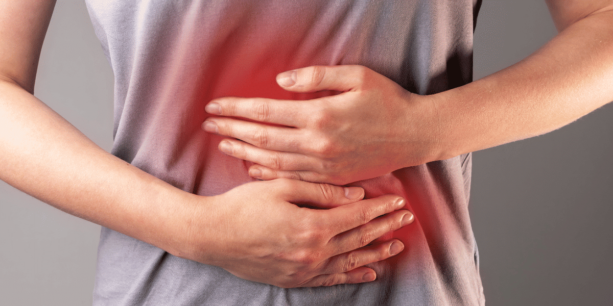 I person clutching their stomach experiencing health issues from long-term NSAID use