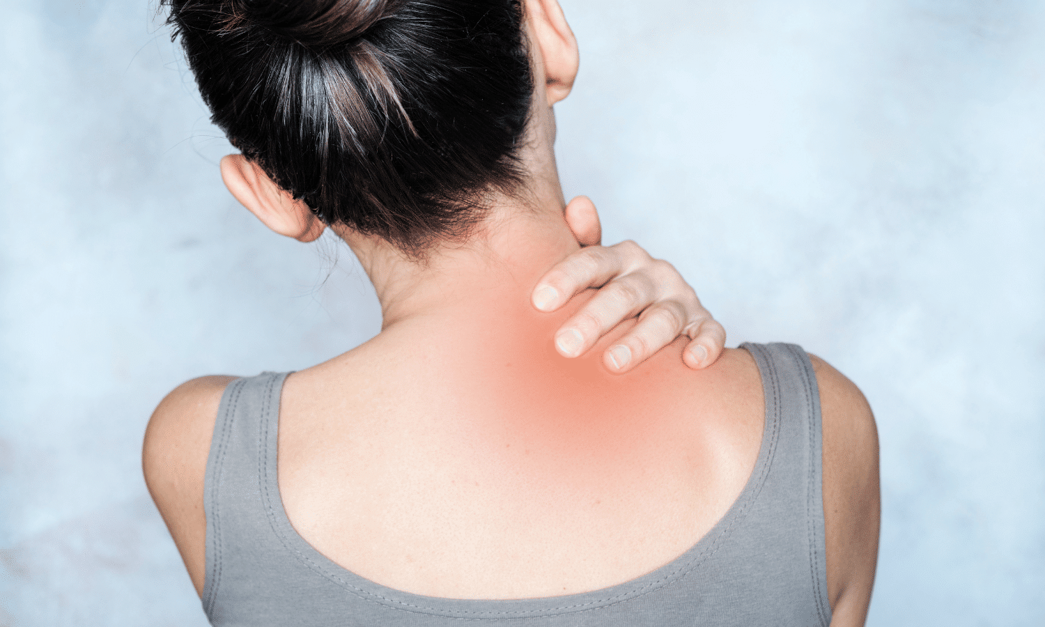 A person grabbing their shoulder and neck area due to pain from a Trigger Point